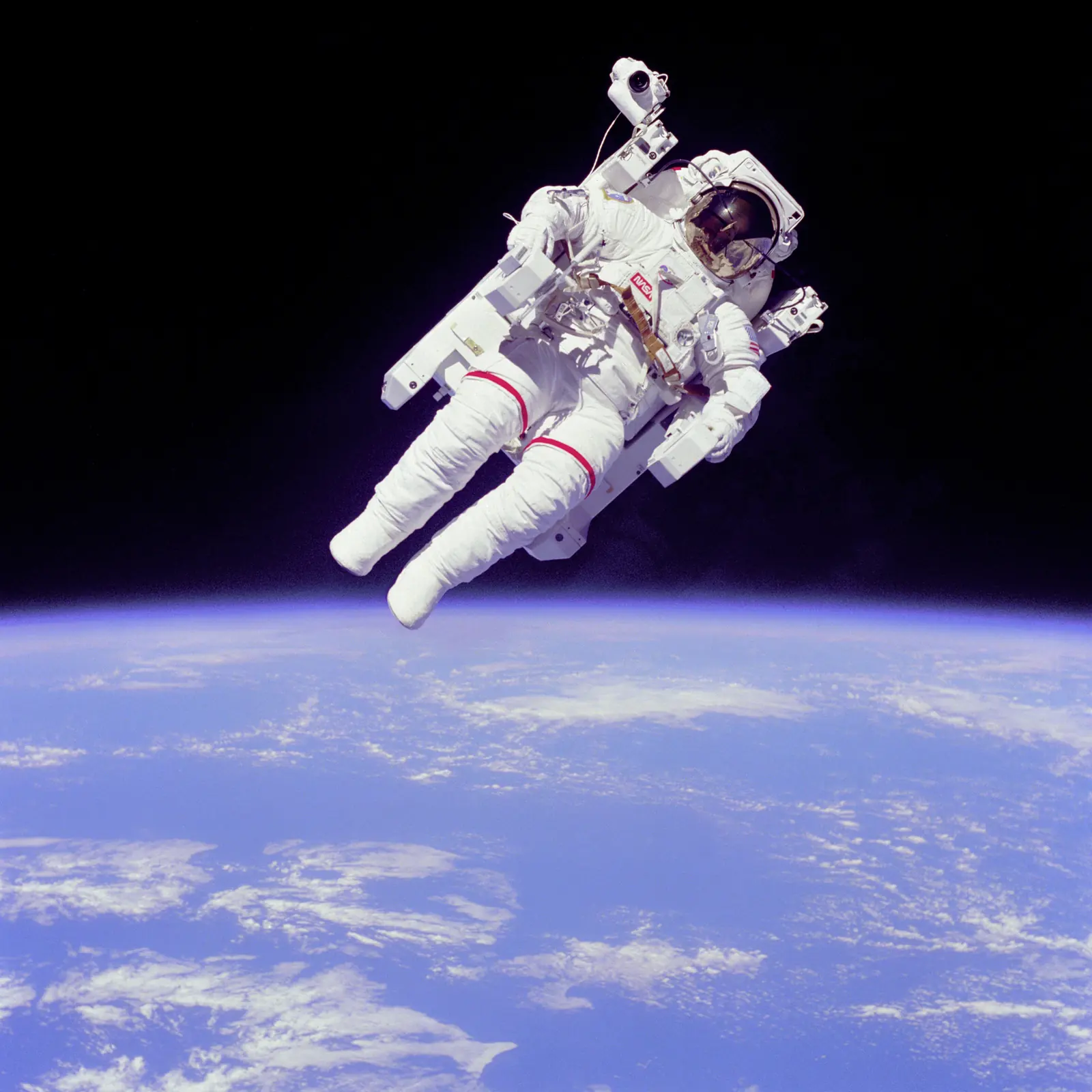 Bruce McCandless floating untethered in a white spacesuit above the blue Earth, 1984