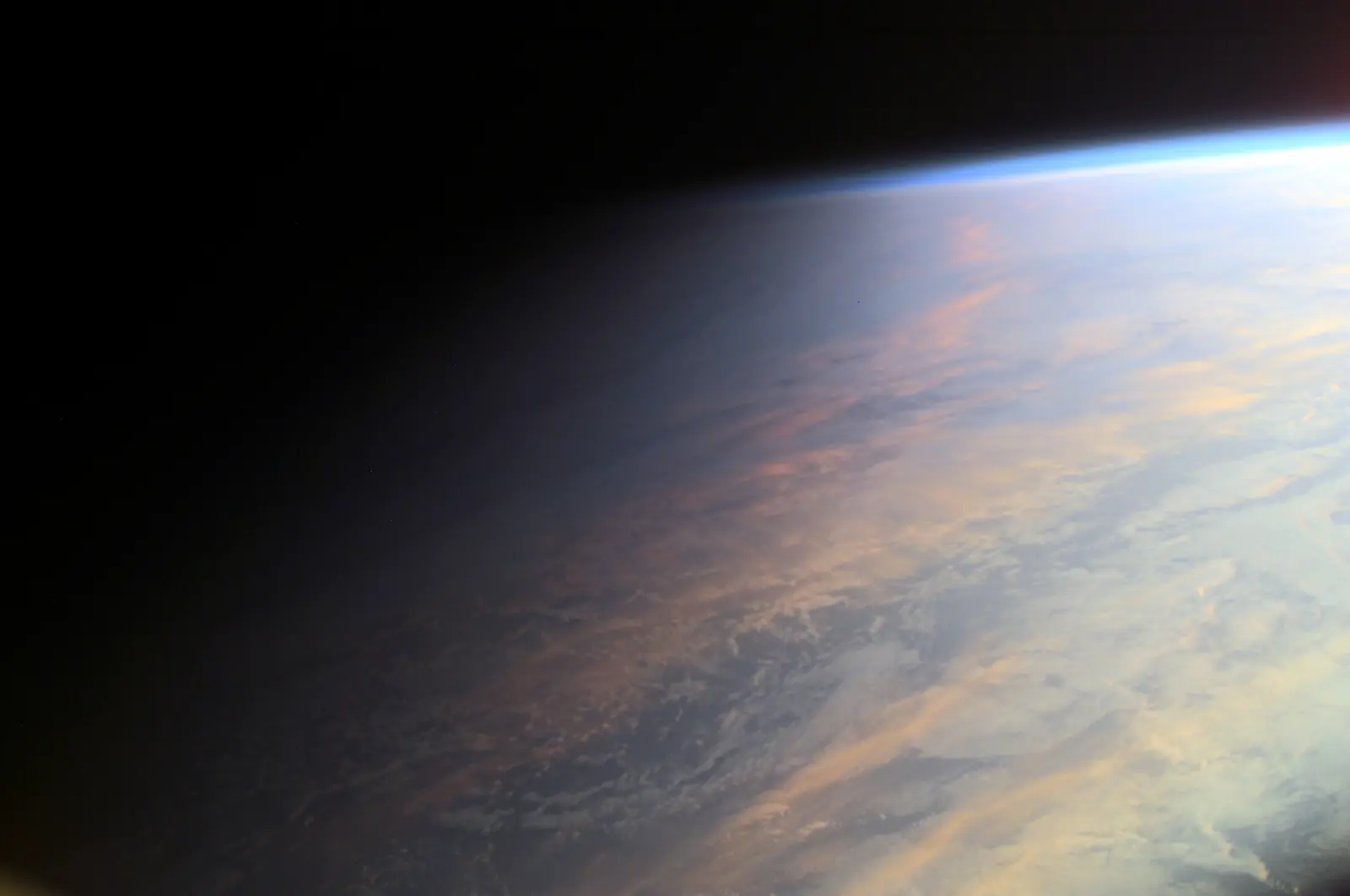 Sunlit clouds fading into night along Earth's day–night line, seen from orbit